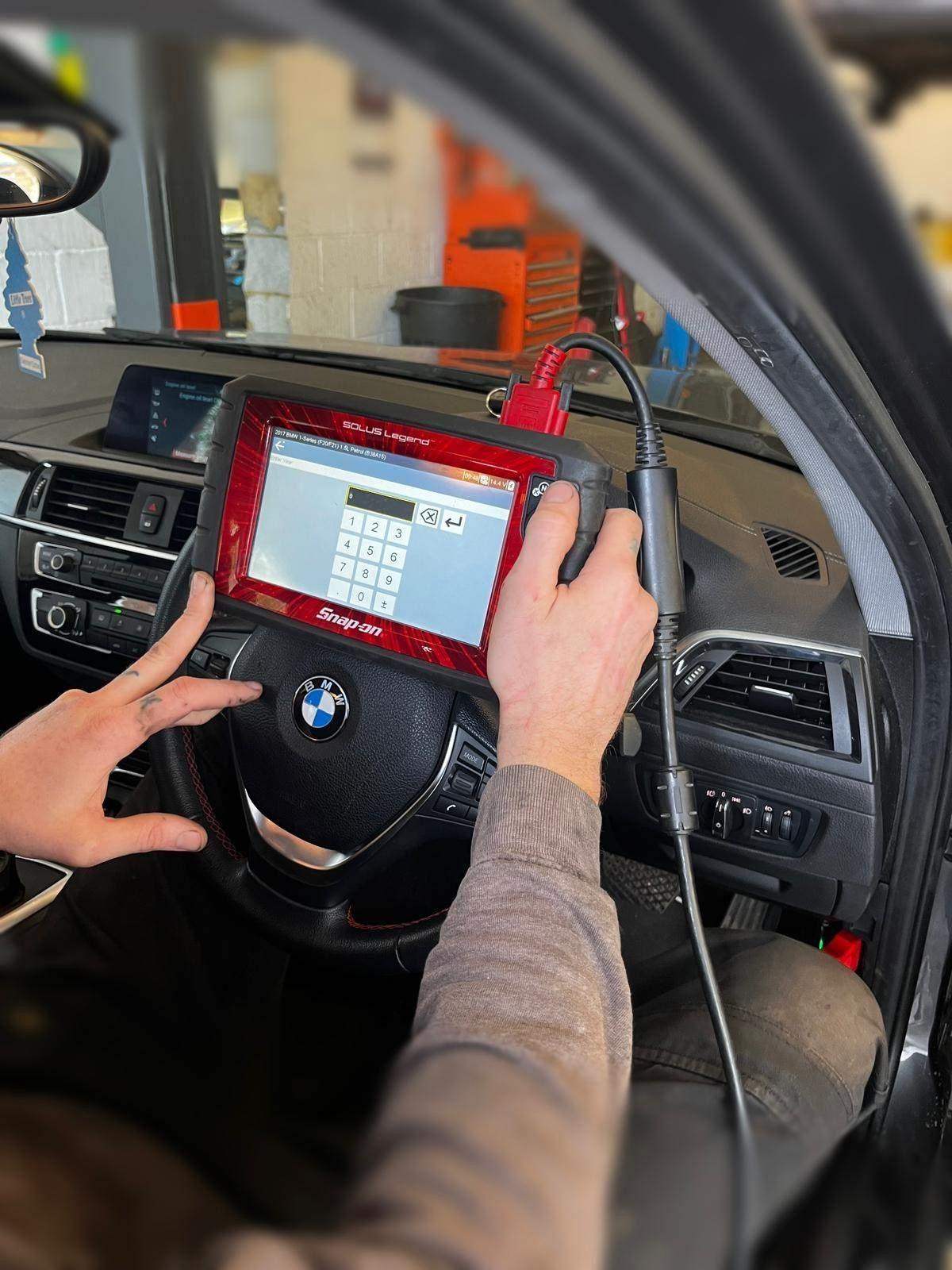 A diagnostic tablet connected to a car