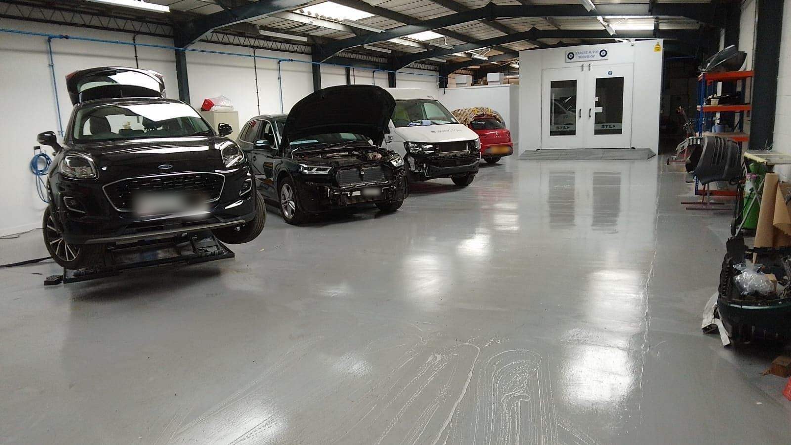Cars parked across the workshop bays